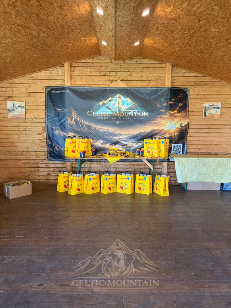 Gelbe Josera-Geschenktüten und Hundeprodukte stehen unter einem großen Celtic-Mountain-Banner.